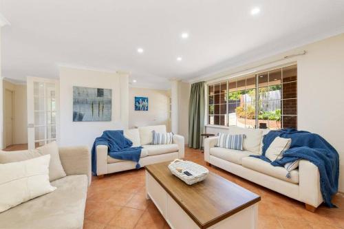 a living room with two couches and a table at Light & bright Falcon Bay family holiday escape in Mandurah