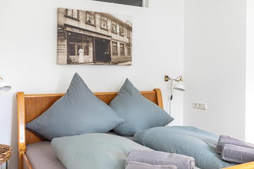 ein Bett mit blauen Kissen darüber in der Unterkunft Hotel Alte Färberei in Goslar