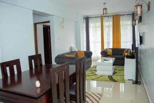 ein Wohnzimmer mit einem Tisch und einem Sofa in der Unterkunft Zoe Homes Greypoint 1br and 2br Apartment 101 in Kericho