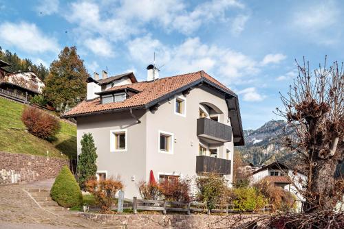 een wit huis met een rood dak bij Apartment Bullaccia Stlarida in Ortisei