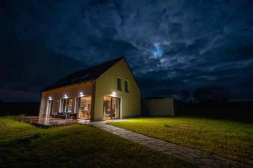 een huis 's nachts met de maan in de lucht bij Vila Jestřábí s výhledem na Lipno, klidná lokalita in Černá v Pošumaví