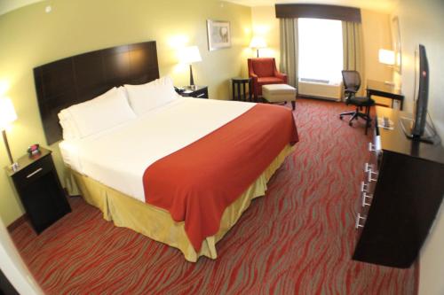 una camera d'albergo con un grande letto e una sedia di Holiday Inn Express & Suites Indianapolis North - Carmel, an IHG Hotel a Carmel