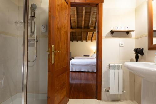 - Baño con puerta que conduce a un dormitorio en Posada 3 Valles, en Liérganes