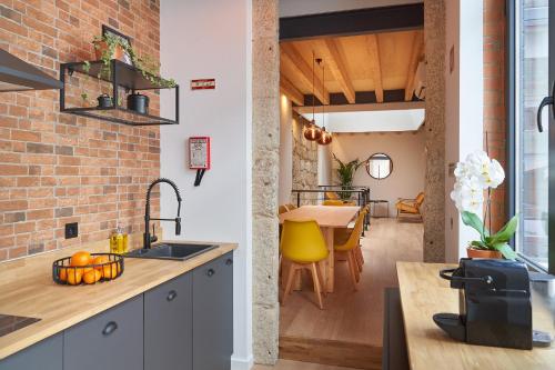 a kitchen and dining room with a brick wall at Brito Capelo 183 in Matosinhos