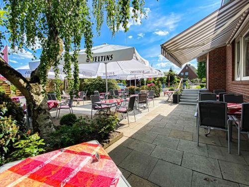 un patio con tavoli e sedie e un edificio di Hotel-Restaurant Vier Linden a Stade