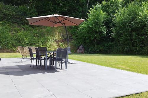 - une table et des chaises sous un parasol sur la terrasse dans l'établissement Le châlet Thomas, à Stavelot