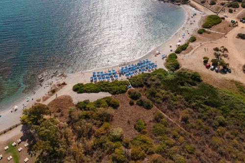 una vista aerea di una spiaggia con ombrelloni blu di SECRET VILLAGE Budoni a Budoni