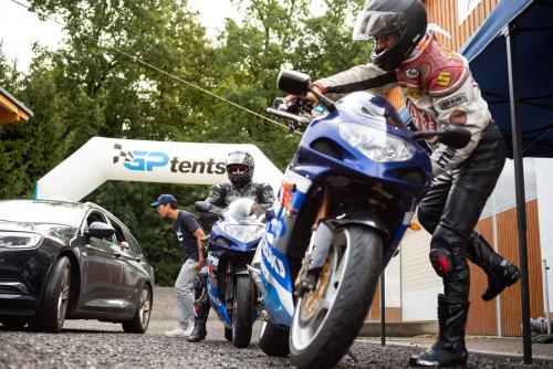 Un homme sur une moto garée à côté d'une voiture dans l'établissement GPtents- Spielberg, à Spielberg