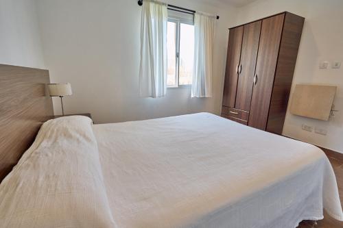 una camera da letto con un grande letto bianco e una finestra di Riviera del Sur - Apart hotel a Miramar