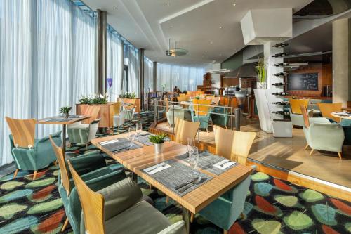 ein Restaurant mit Holztischen und -stühlen und eine Cafeteria in der Unterkunft Quality Hotel Brno Exhibition Centre in Brünn