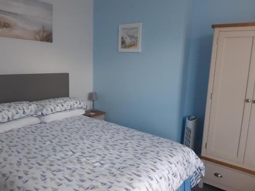 una camera con letto e parete blu di South Rising Guest House a Poole