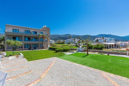 a large building with a lawn in front of it at Theo Star Beach Hotel in Malia