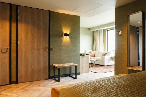 une chambre d'hôtel avec un lit et un salon dans l'établissement Van der Valk Hotel Apeldoorn - de Cantharel, à Apeldoorn