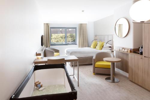 - une chambre d'hôtel avec un lit et un miroir dans l'établissement Crowne Plaza Lyon - Cité Internationale, à Lyon