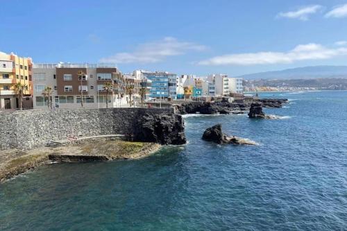 un cuerpo de agua con rocas en el agua en Loft Sol y Luna en Las Palmas de Gran Canaria, en Las Palmas de Gran Canaria