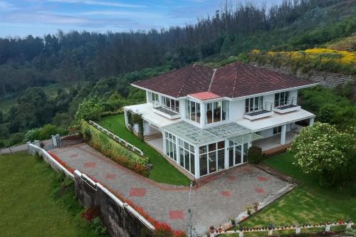 eine Luftansicht eines Hauses auf einem Hügel in der Unterkunft StayVista at The Lilly Ooty with Breakfast in Udagamandalam