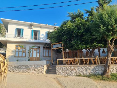 a house with a table and chairs in front of it at Big apartment on the beach in Tolo