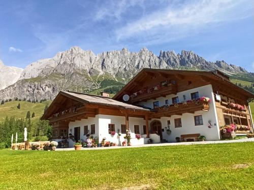 uma casa nas montanhas com um relvado verde em Gästehaus Gschwandtner em Mühlbach am Hochkönig