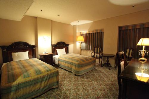 A bed or beds in a room at Hirosaki Park Hotel