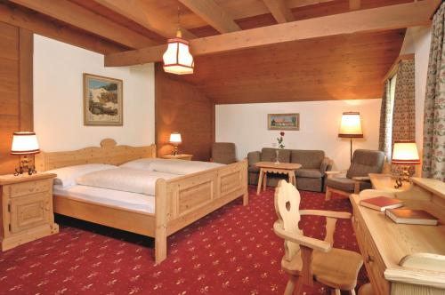 een slaapkamer met een bed en een woonkamer bij Hotel Gletschergarten in Grindelwald