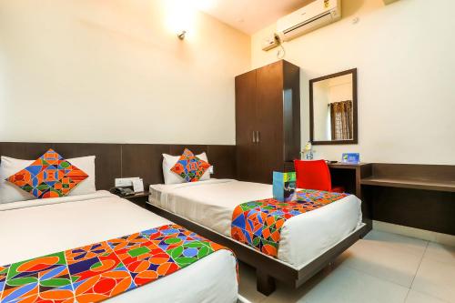 een hotelkamer met 2 bedden en een bureau bij FabHotel RMS Comforts - Nr Yeshwantpur Railway Station in Bangalore