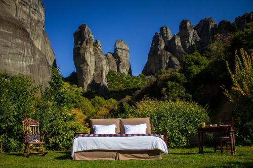 a bedroom with a bed in front of some rocks at Pyrgos Adrachti in Kalabaka