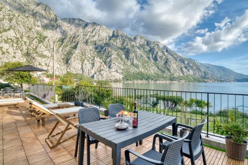 a patio with a table and chairs and a mountain at Beachfront Villa Nautica in Kotor