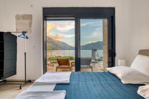 a bedroom with a bed and a sliding glass door at Beachfront Villa Nautica in Kotor