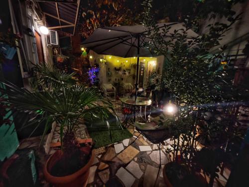 un patio con piante e ombrellone di notte di Hotel Maria a Tbilisi City