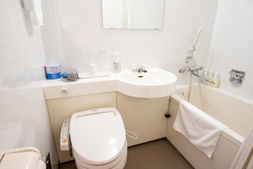 een witte badkamer met een toilet en een wastafel bij le Lac HOTEL Otsu Ishiyama in Otsu