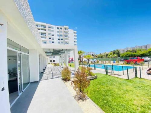 un gran edificio blanco con patio y piscina en Departamento a pasos de la playa avenida del mar, en La Serena