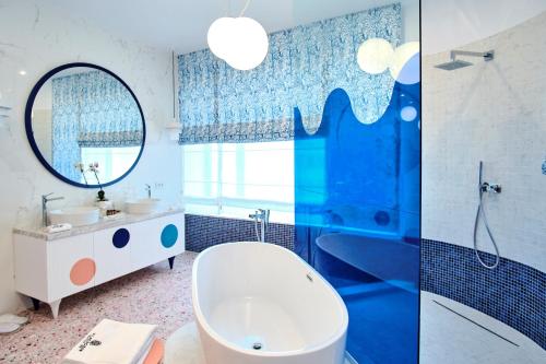 La salle de bains est pourvue d'une baignoire, d'un lavabo et d'un miroir. dans l'établissement Vilacrosse Boutique Inn, à Bucarest