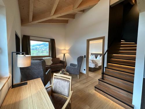 un salon avec un escalier et une chambre dans l'établissement Pension Dorferwirt, à Bramberg am Wildkogel