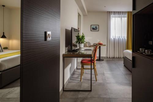 a hotel room with a desk and a bed at Urban Rooms by NEU Collective in Il-Gżira