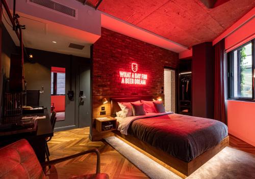 een slaapkamer met een rode bakstenen muur en een bed bij BrewDog DogHouse Manchester in Manchester