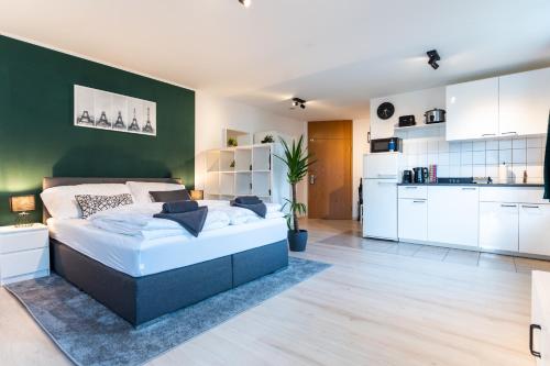 um quarto com uma cama e uma parede verde em Mercedes I Stuttgart I Kitchen I Home Office I Parkplatz em Böblingen