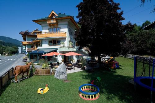 un bâtiment sur le côté d'une route avec une cour avec des jouets dans l'établissement Hotel Gasthof Obermair, à Fieberbrunn