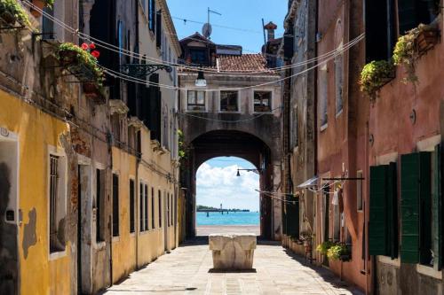 uma arcada num beco entre edifícios com o oceano em Bricola Biennale Apartments em Veneza