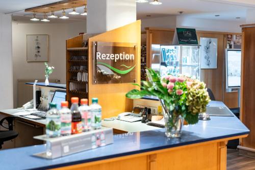 - une réception avec un vase de fleurs sur un comptoir dans l'établissement Hotel am Tierpark Gotha, à Gotha