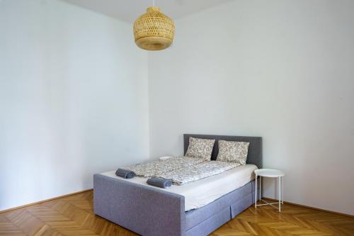 a bed in a room with a white wall at Vienna City Apartments 1090 Vienna in Vienna