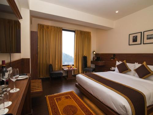 a hotel room with a large bed and a desk at Tree of Life Indra Mandala Hotel, Gangtok in Gangtok