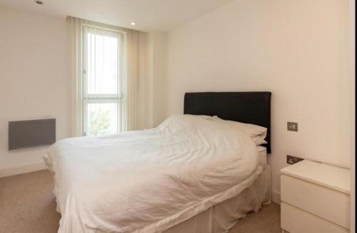 1 dormitorio con cama blanca y ventana en Arena Apartment, en Mánchester