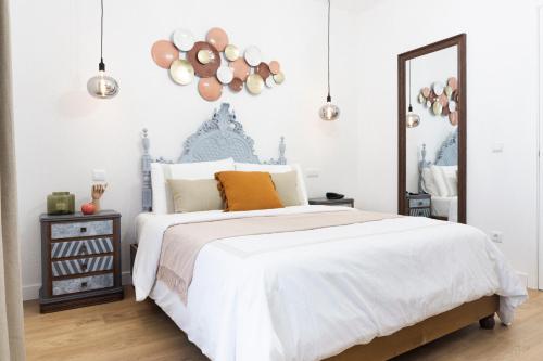 - une chambre avec un lit et un miroir dans l'établissement Lugar do Ourives Boutique Hotel, à Senhora das Febres