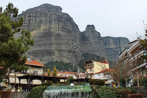 een berg op de achtergrond van een stad met een waterval bij Aeolic Star Hotel in Kalabaka