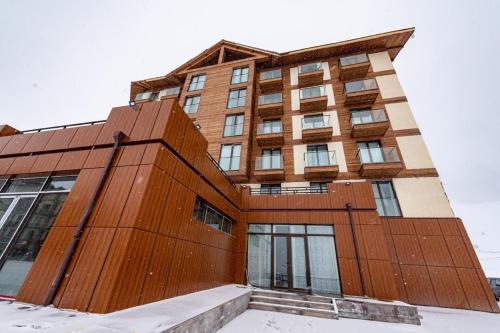 a building in the snow in front at Evdo Apartments Loft2 Wooden House in Gudauri