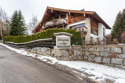 ein Holzhaus mit einem Schild davor in der Unterkunft Mountain Lodge Leogang - Top4 in Leogang