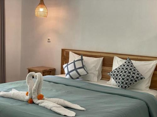 um quarto com duas toalhas de cisne numa cama em Hello Penida House em Nusa Penida