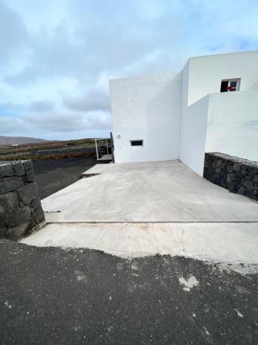 um edifício branco sentado no topo de uma estrada em El Cercado em Tinajo