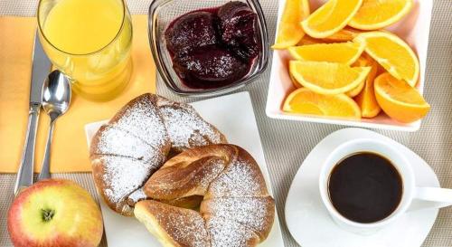 una mesa con un plato de pan y una taza de café en Hotel Conquistador Santo Domingo, en Santo Domingo