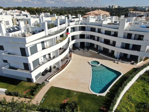 een luchtzicht op een groot gebouw met een zwembad bij Apartment 2 bedrooms , centre of Alvor, open view and private parking in Alvor